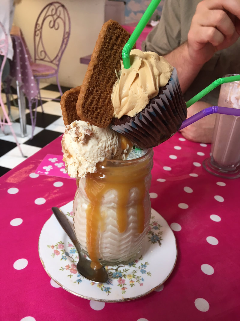Milkshake topped with icecream, biscuit and cupcake