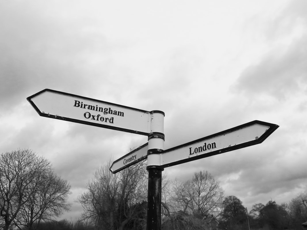 Black and white photo of fingerpost pointing to Birmingham, London and Coventry