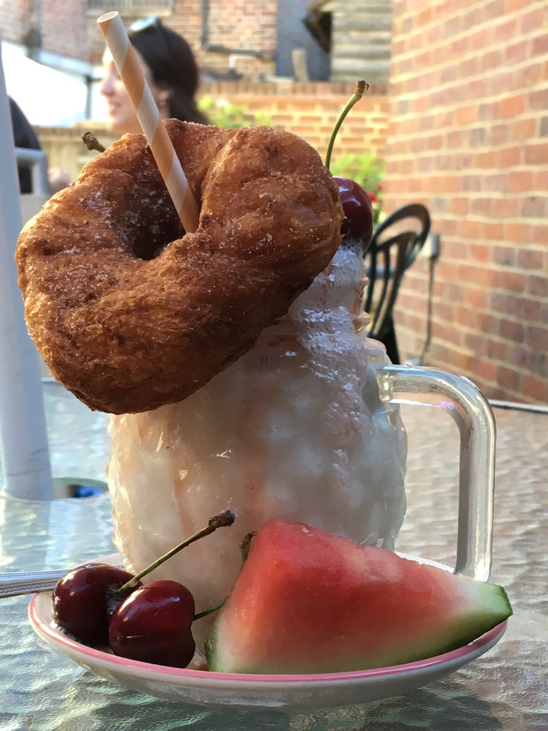 Milkshake topped with doughnut and cherry