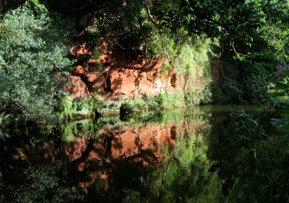 red cliff reflected in river