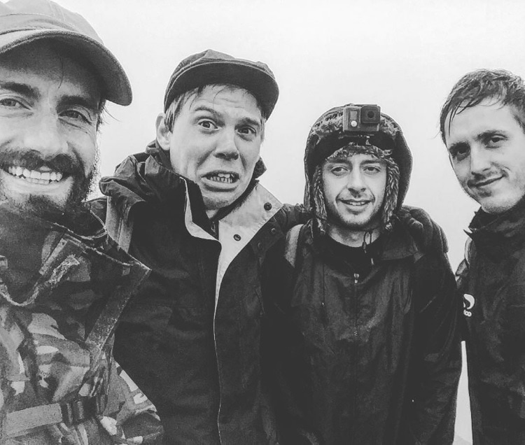 Black and white photo of four men in outdoor clothing