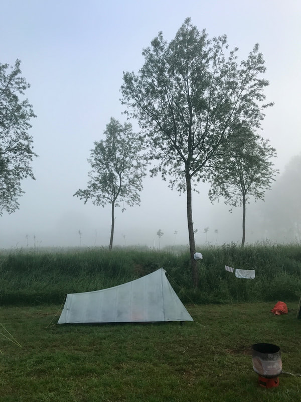 Tent shown side-on, with trees silhouetted in mist behind