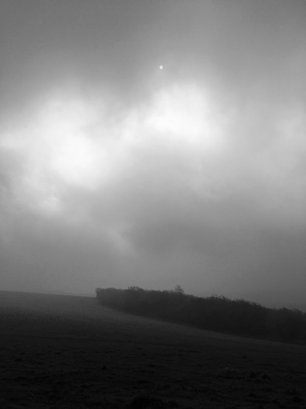 Black and white landscape with sun in clouds