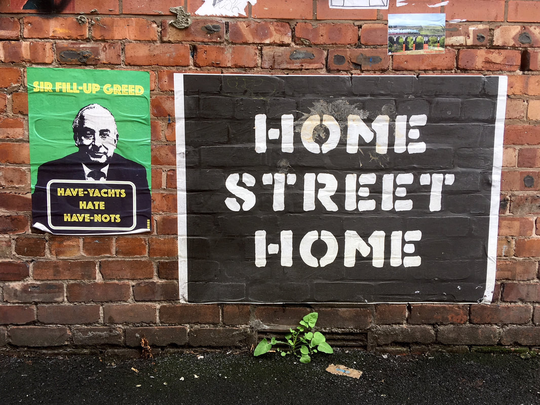 Posters on brick wall - one says HOME STREET HOME