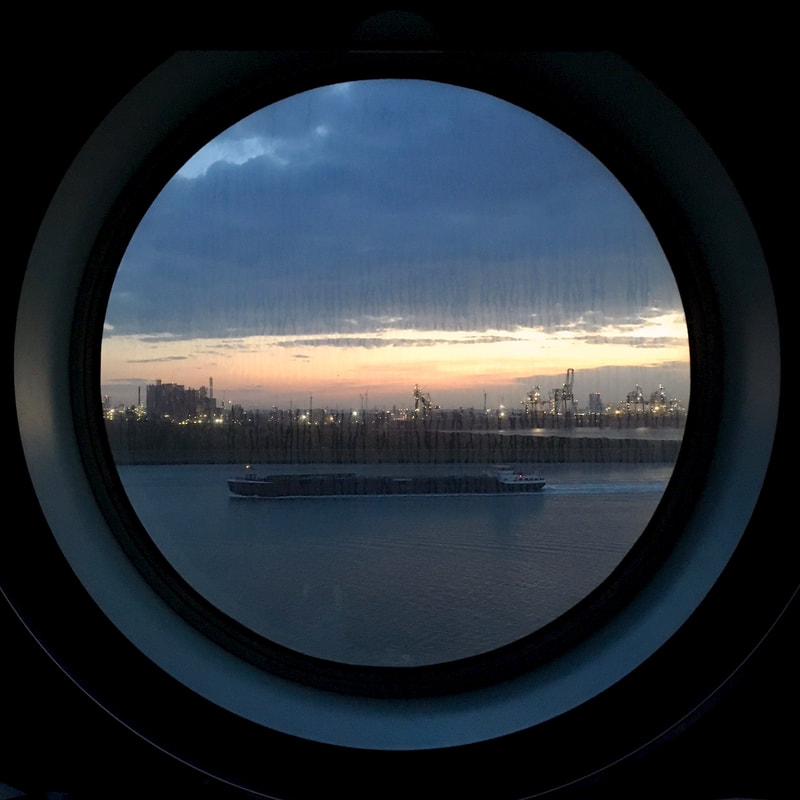 water and lights and sunset through a round window
