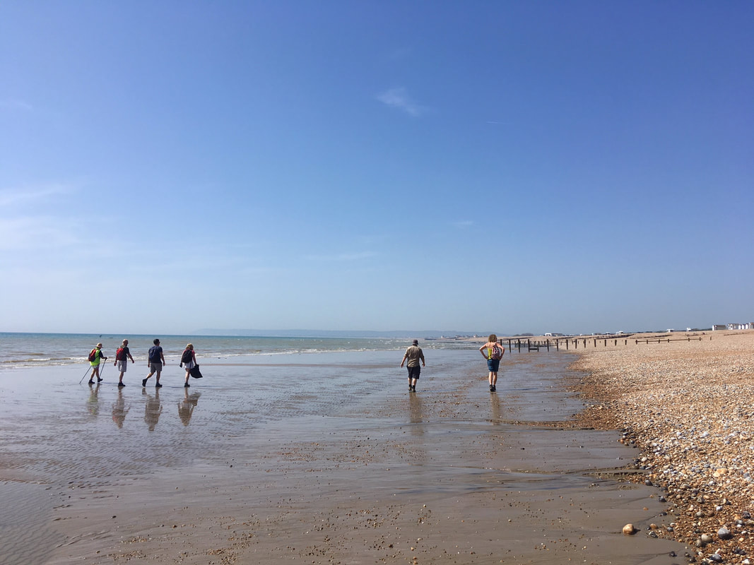 people walking along beach at low tide