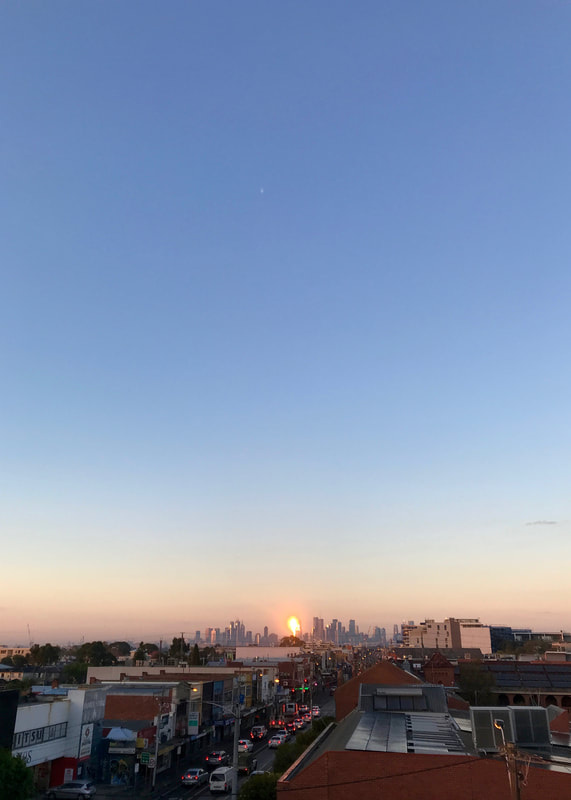 City skyline with a bright orange flare of light on one of the buildings