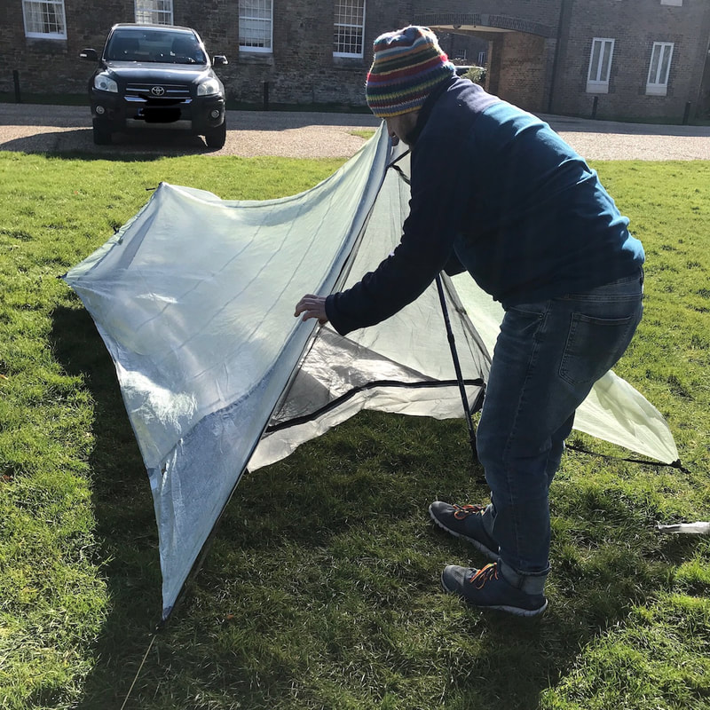 Person setting up tent in wind