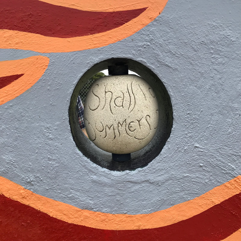 Wall painted in orange, red and grey, with a concrete 'bead' set in it. On the bead you can see 