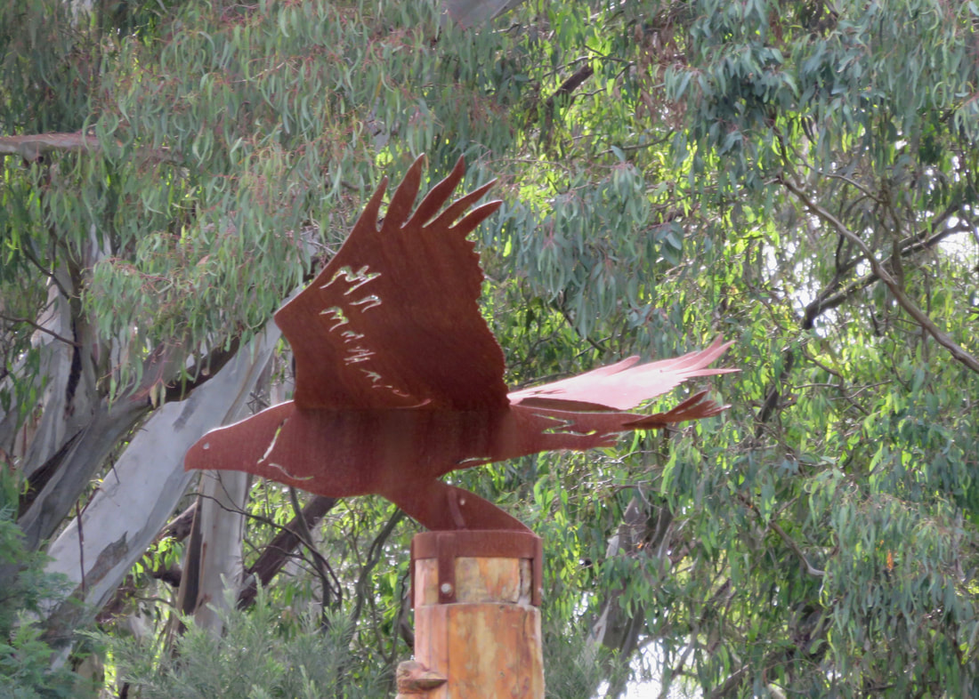rusted steel sculpture of a big bird in flight