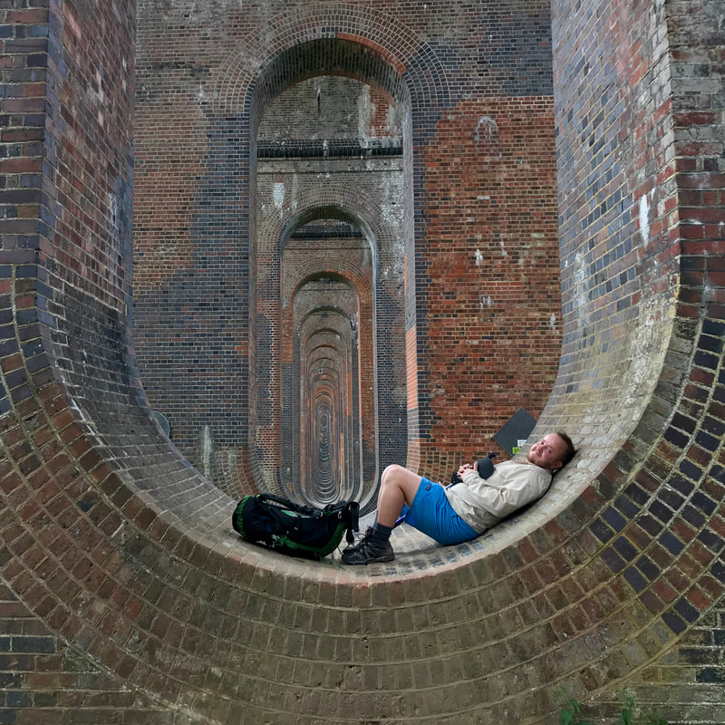 person lying in the bottom of a brick arch