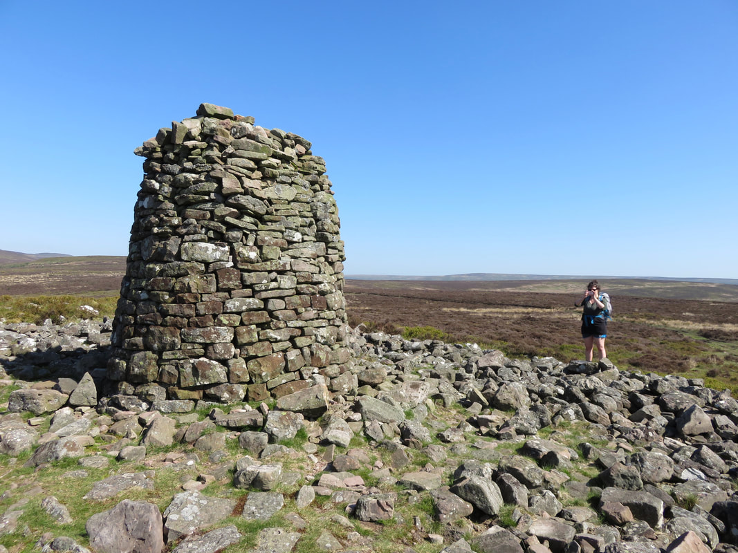 large round stone cairn and photographer