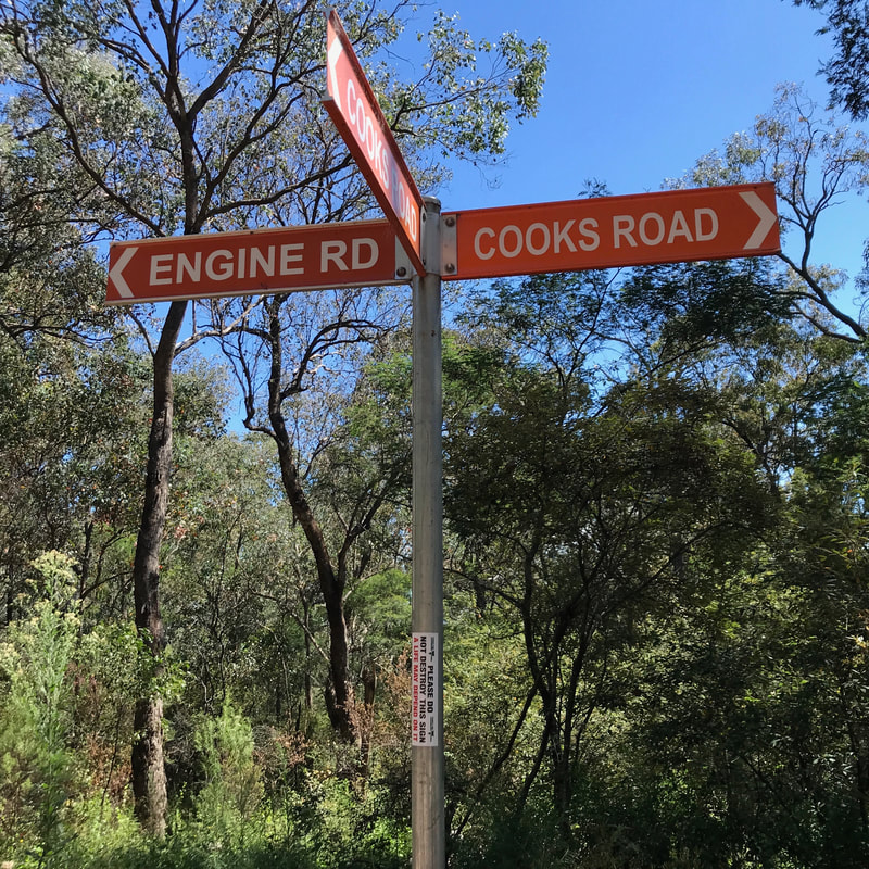 Orange road signs for Engine Rd and Cooks Road