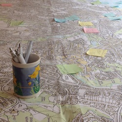 Large map, mug of pens and sticky notes