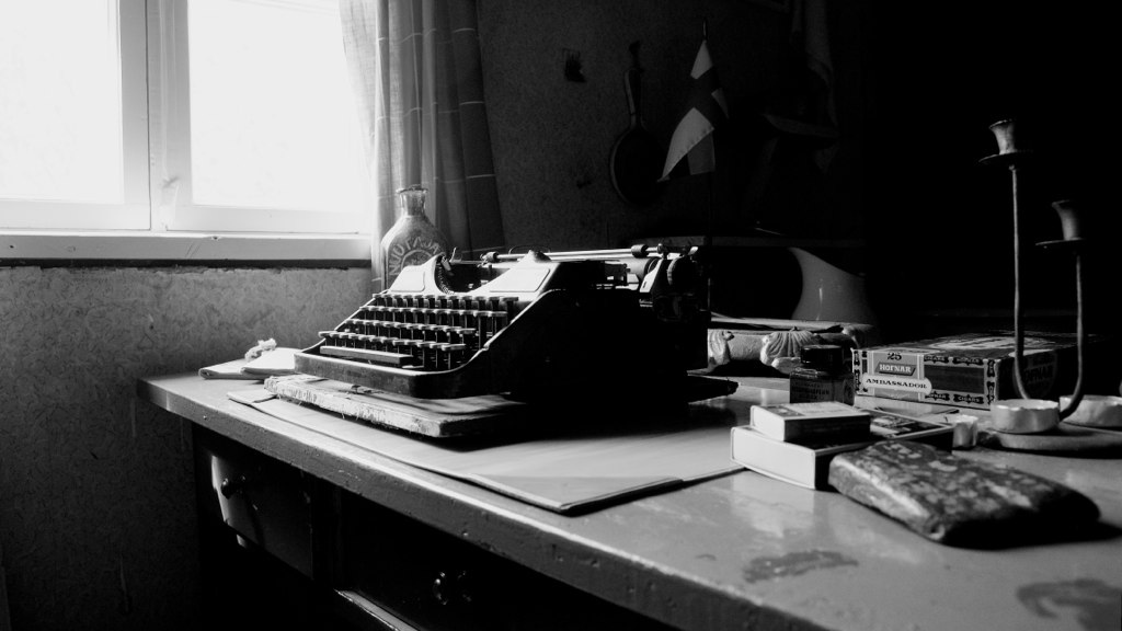 Black and white photo of a desk and typewriter