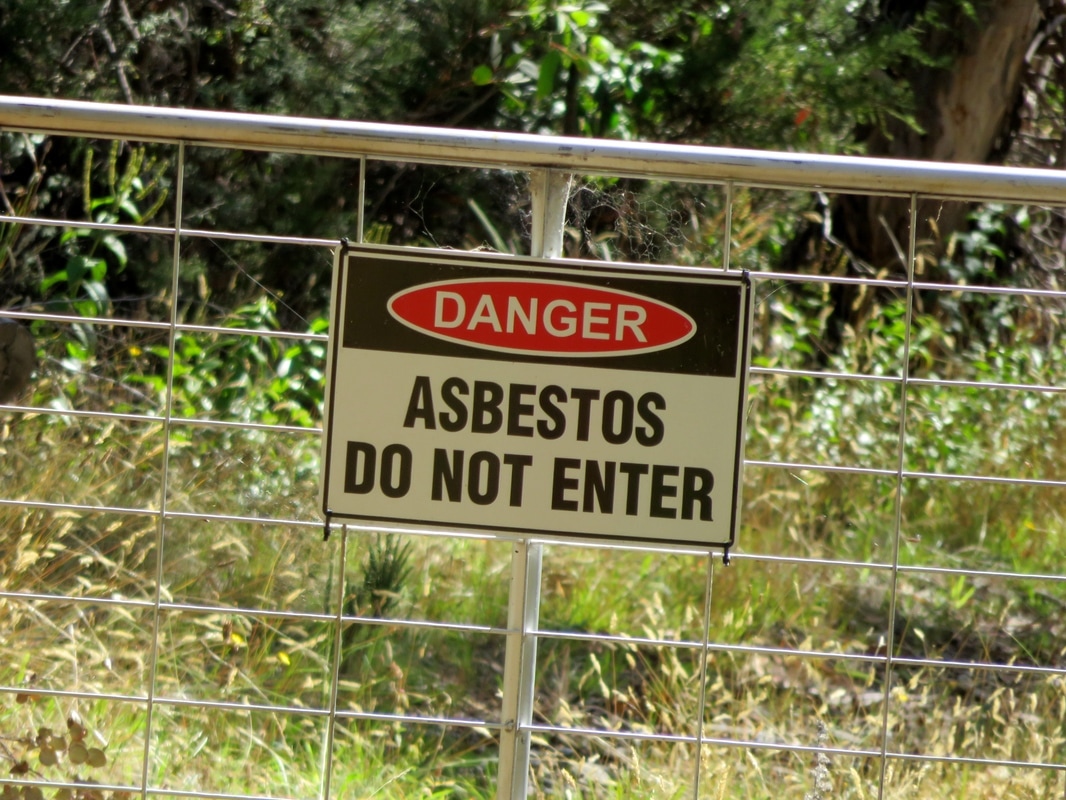 Gate with asbestos warning sign