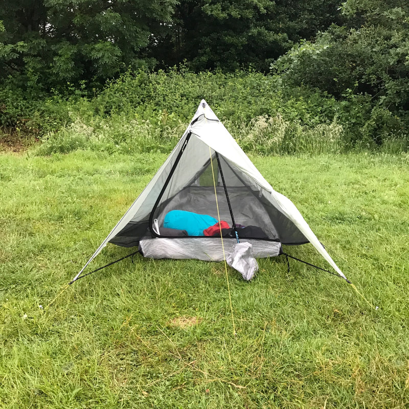 Front view of tent with grass and trees behind