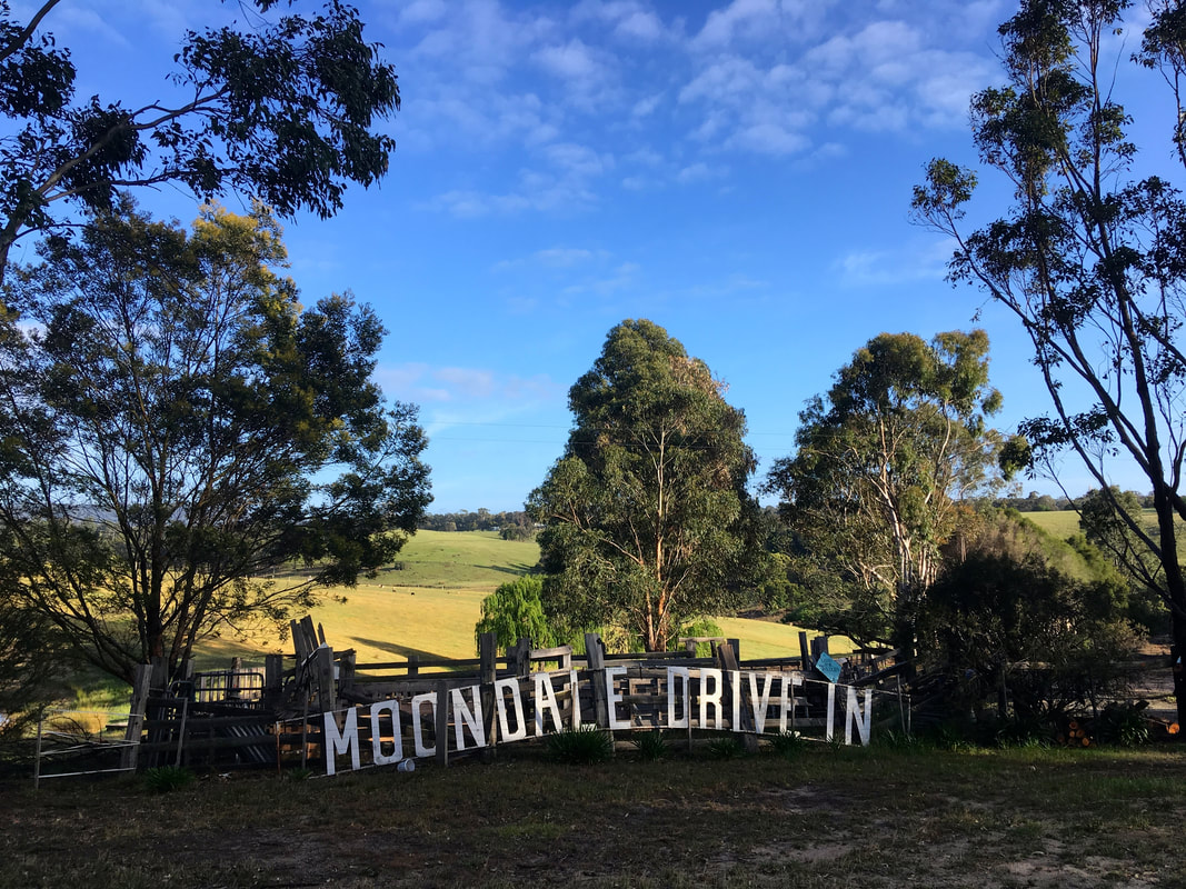 Hollywood-style sign for a drive in cinema rested up against a sheep race