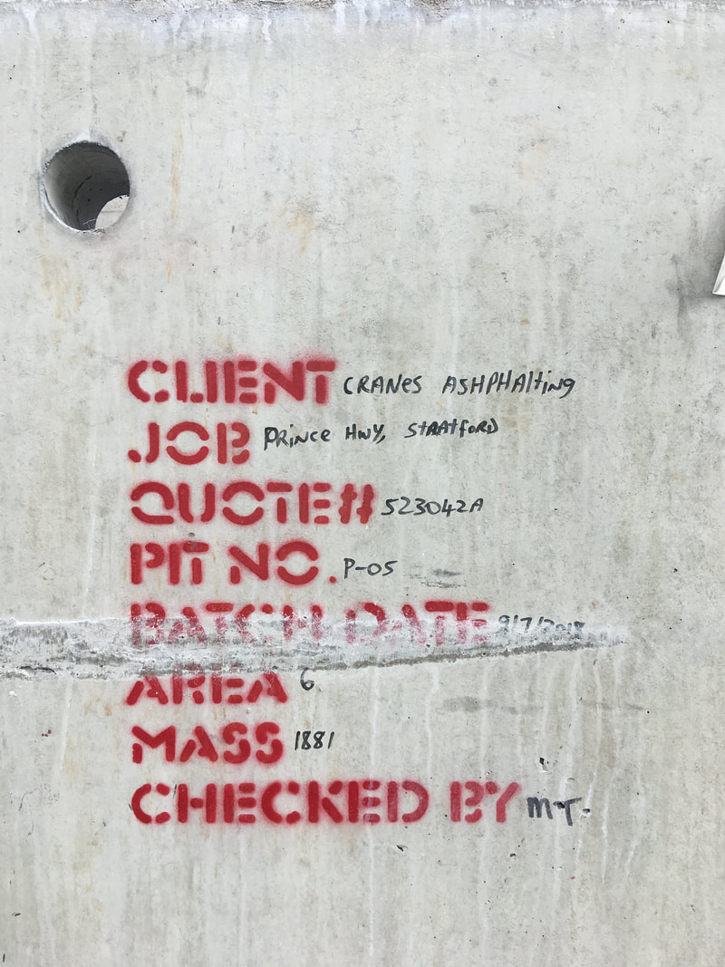 Concrete with construction info stencilled and written on it