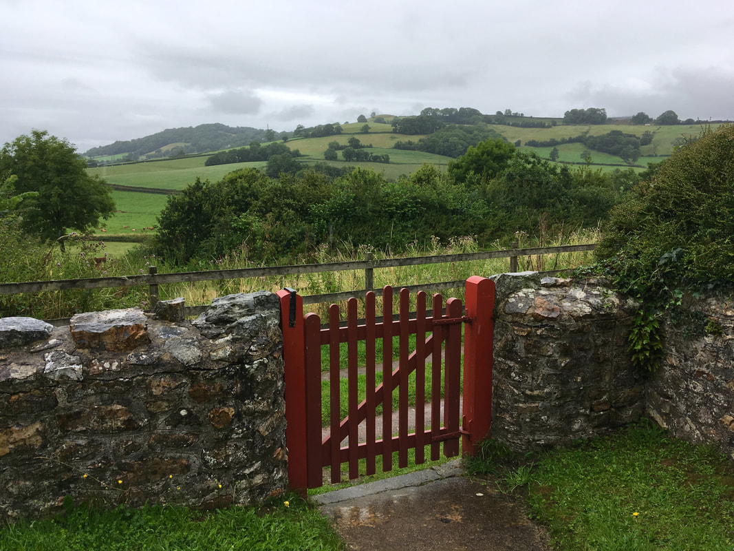 Red wooden gate and rolling green landscape