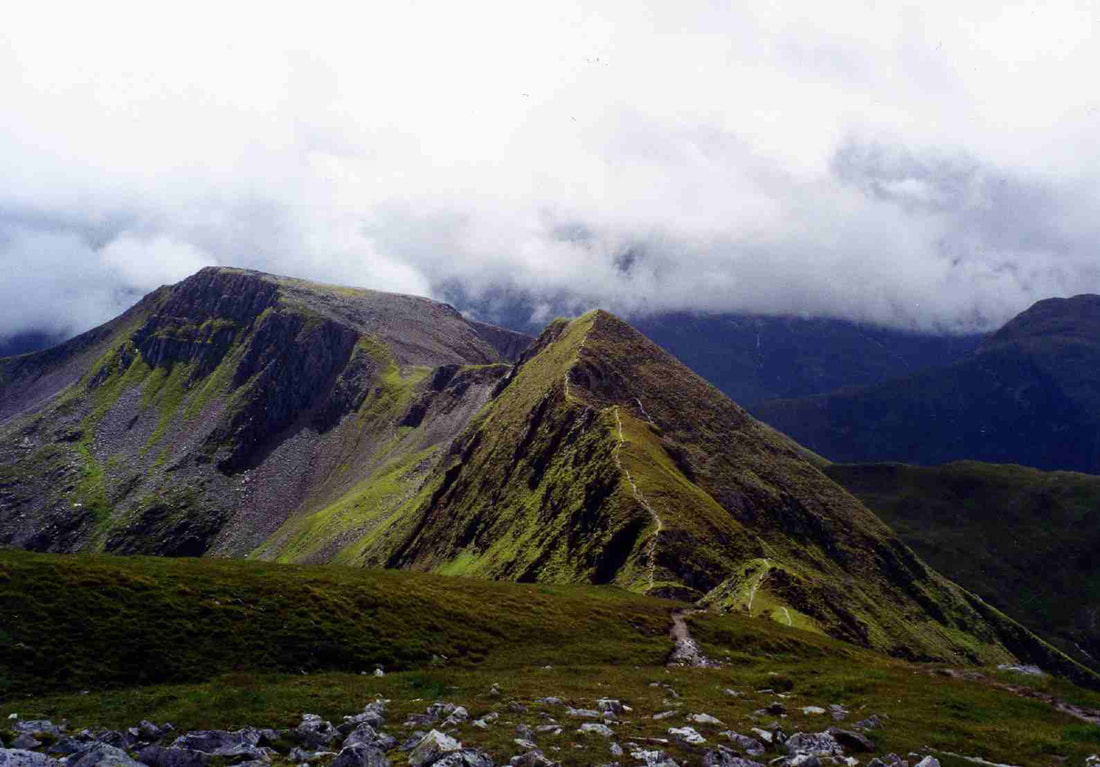 Path along mountain ridge under cloud